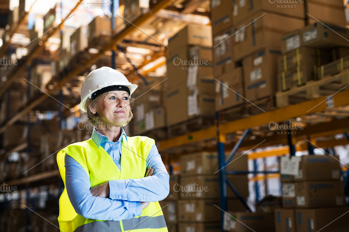 Senior woman manager or supervisor standing in a warehouse, arms crossed. in Graphics - product preview 8