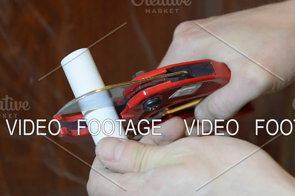Cutting the plastic pipe with a pruner