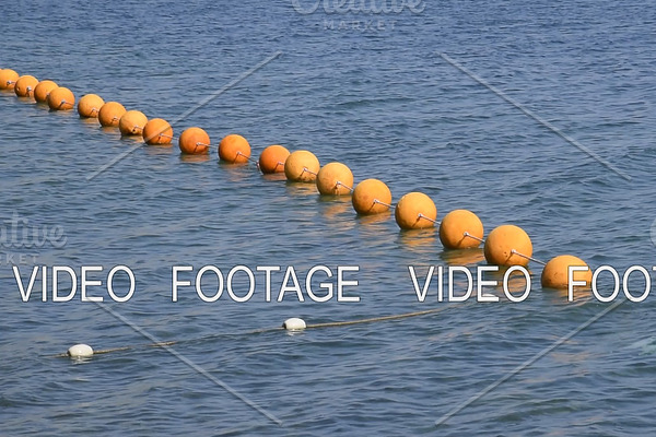 Orange buoys on a rope in the sea