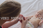 A woman massaging baby girl's foot