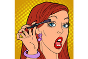 Woman paints eyelashes, make-up