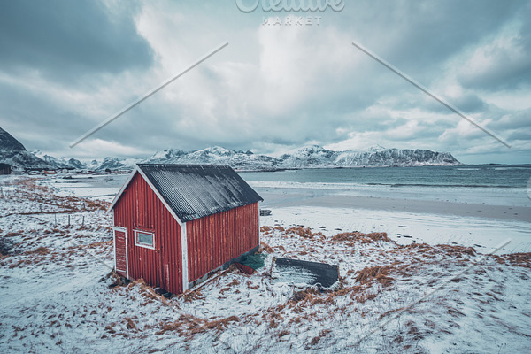 Red rorbu house shed on beach of