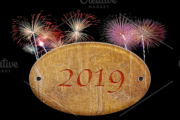 Wooden sign of 2019 with fireworks.