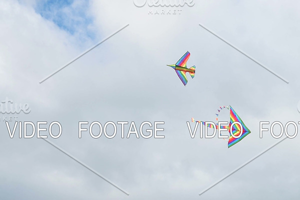 Two kites flying in cloudy sky