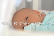 Newborn baby lying quietly in bed
