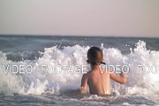 Child bathing in the sea and waves