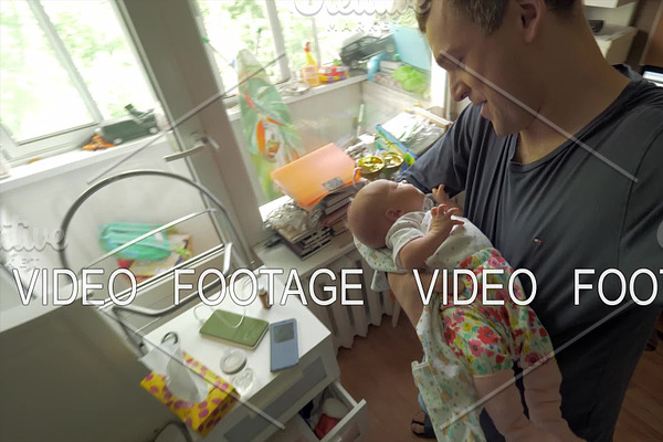 Dad lulling baby daughter at home
