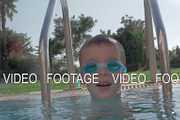 Cheerful child in goggles bathing in