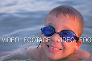 Smiling child in goggles swimming in