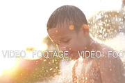 Child taking beach shower at sunset