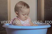 Cute baby girl in a round blue tub 2