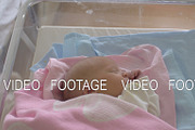 Newborn baby girl in crib being
