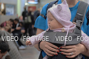 Cute baby girl in a baby carrier at
