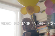 Playful baby girl with balloons in