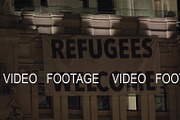 Night view of Refugee Welcome banner