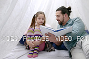 little girl and her father reading a