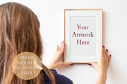 Woman holding frame on wall Mockup
