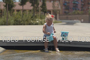 Baby girl playing in fountain on hot