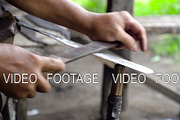 Sharpening a machete with a rasp.