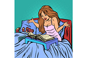 woman in bed reading a book