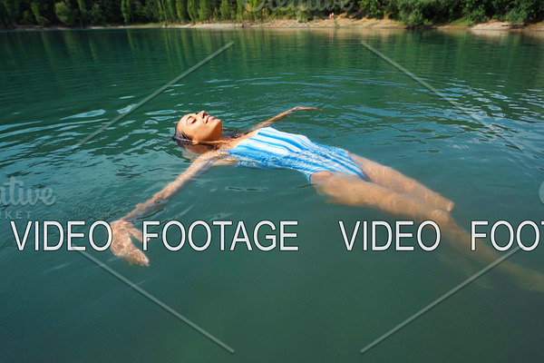 young relaxed woman swimming on back
